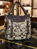 Coach handbag with brown and beige pattern on a marble surface