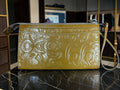 Grand porte-monnaie de poignet Coach Poppy en cuir verni jaune moutarde avec motif « C » embossé