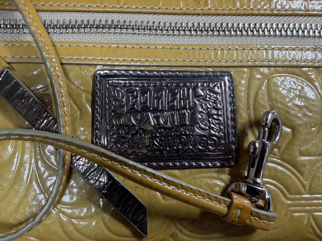Grand porte-monnaie de poignet Coach Poppy en cuir verni jaune moutarde avec motif « C » embossé
