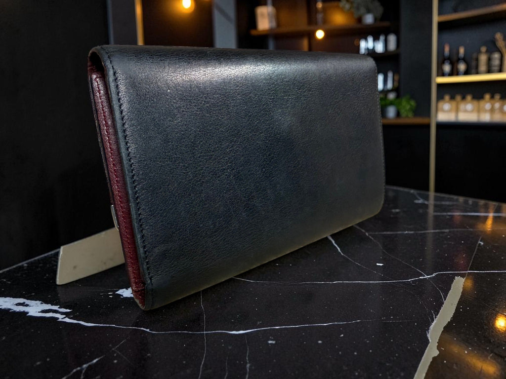 Cartier Cabochon Leather International Flap Wallet (Black with Red Interior).