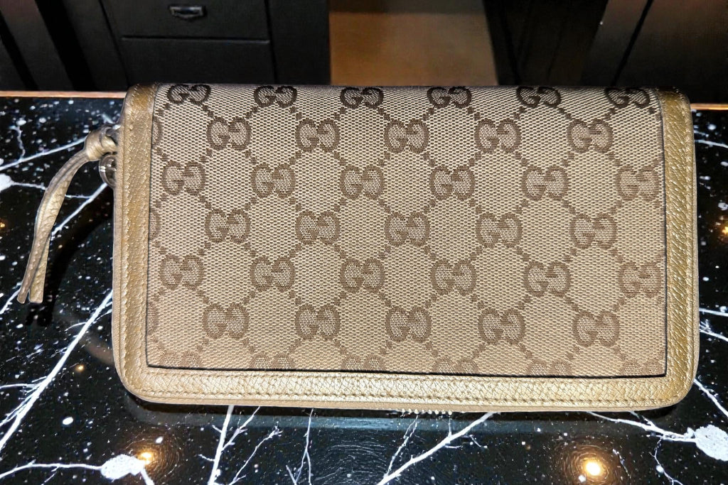 Gucci wallet with monogram pattern on a dark background