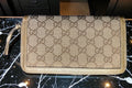 Gucci wallet with monogram pattern on a dark background